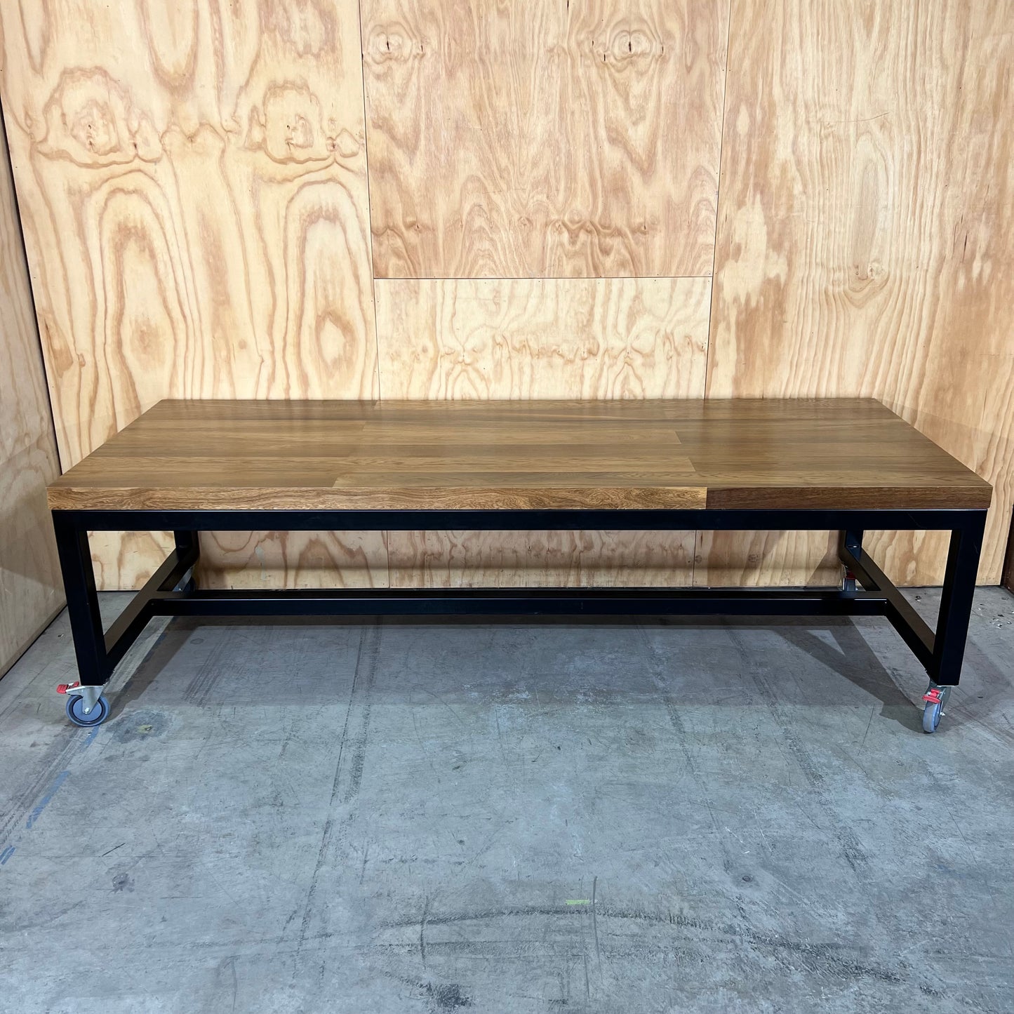 Timber table on black metal frame with castors