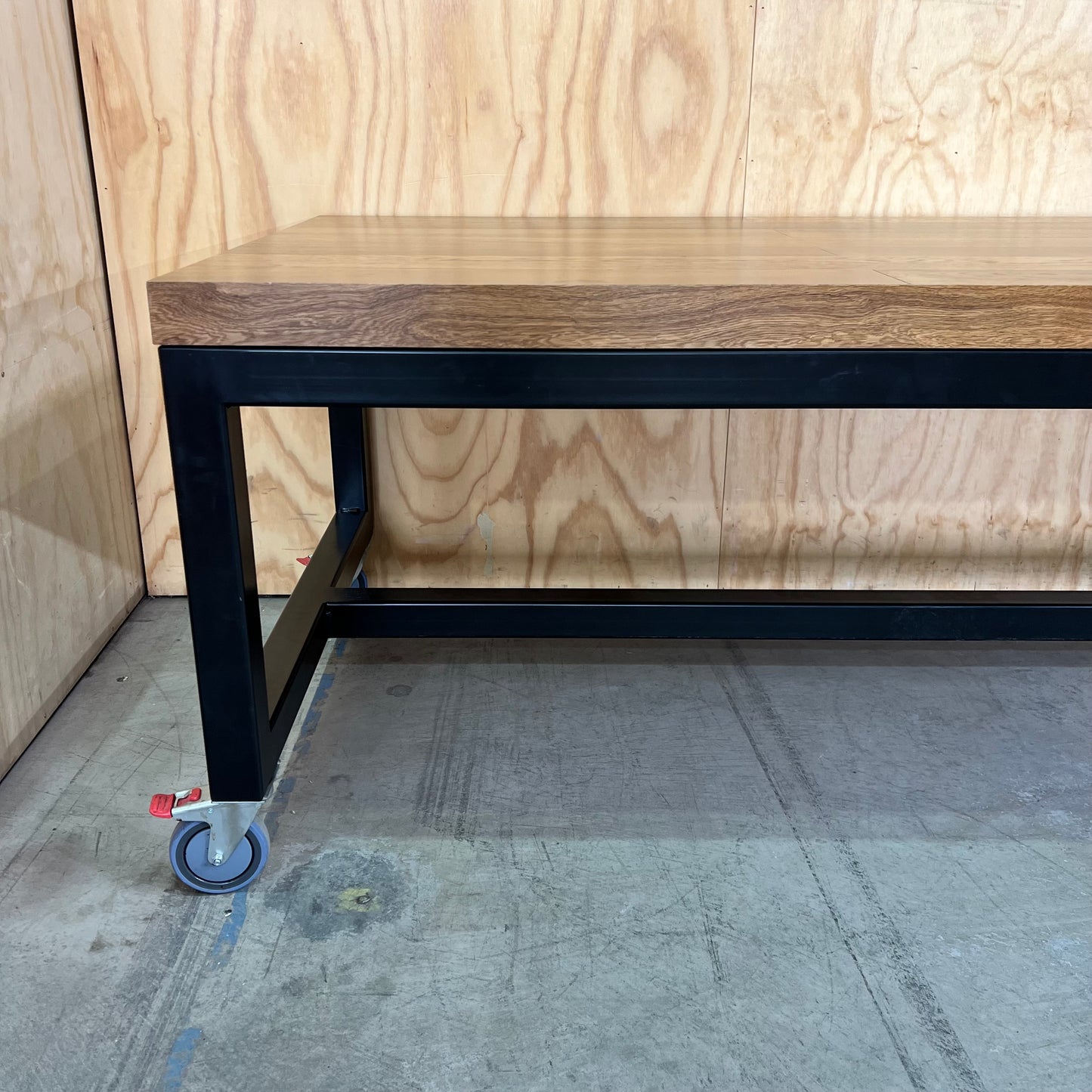 Timber table on black metal frame with castors