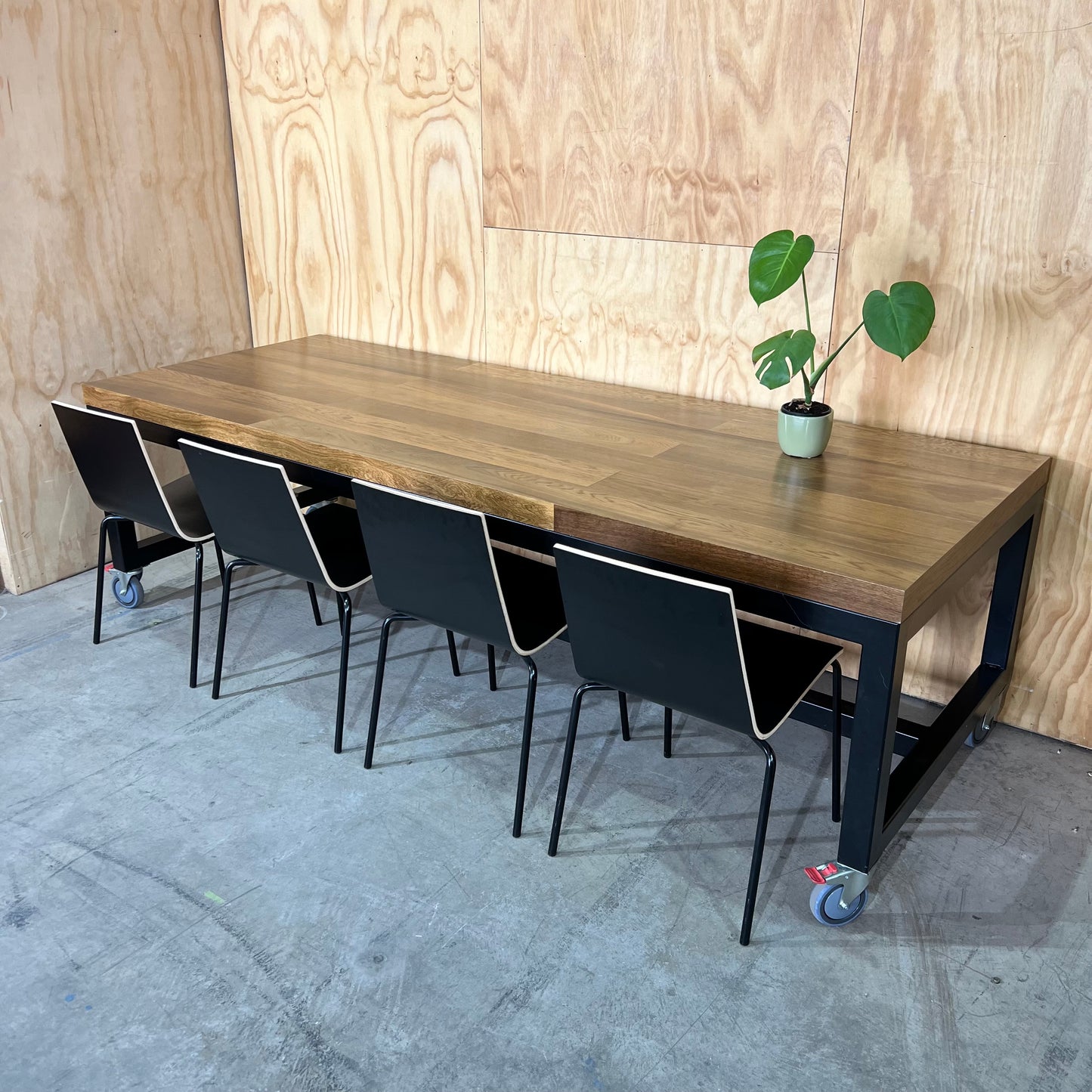 Timber table on black metal frame with castors