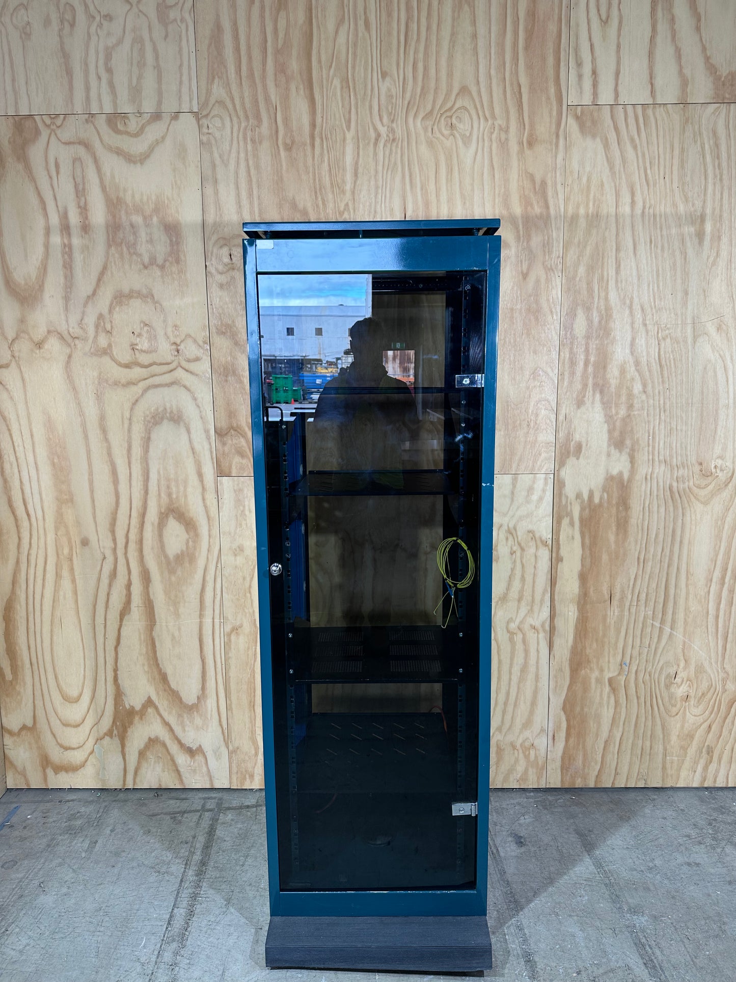 Tall dark green server cabinet with glass doors