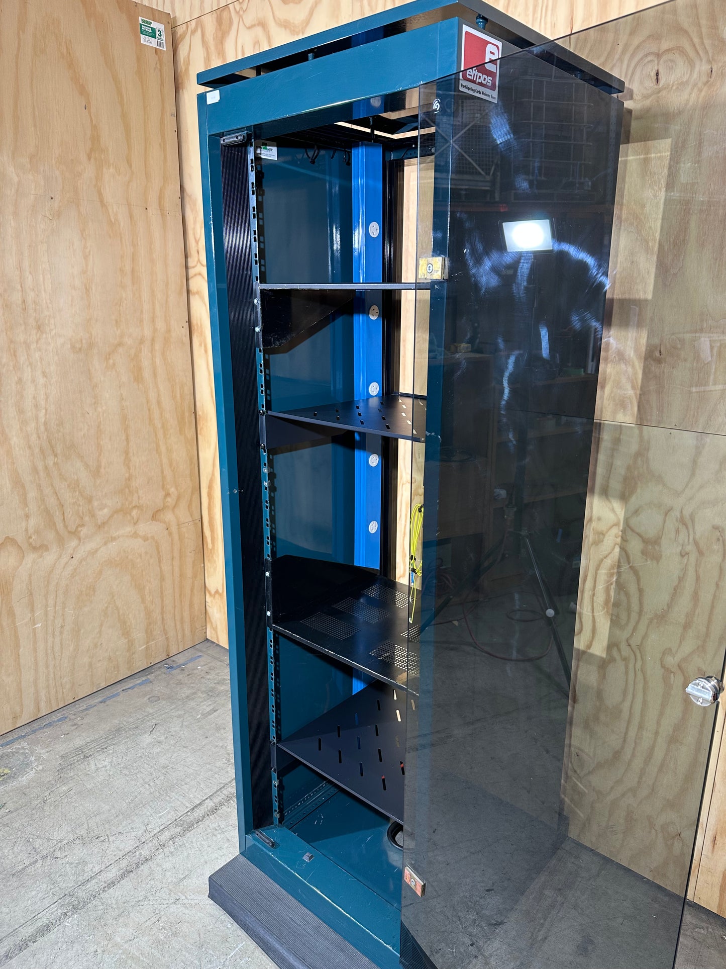 Tall dark green server cabinet with glass doors