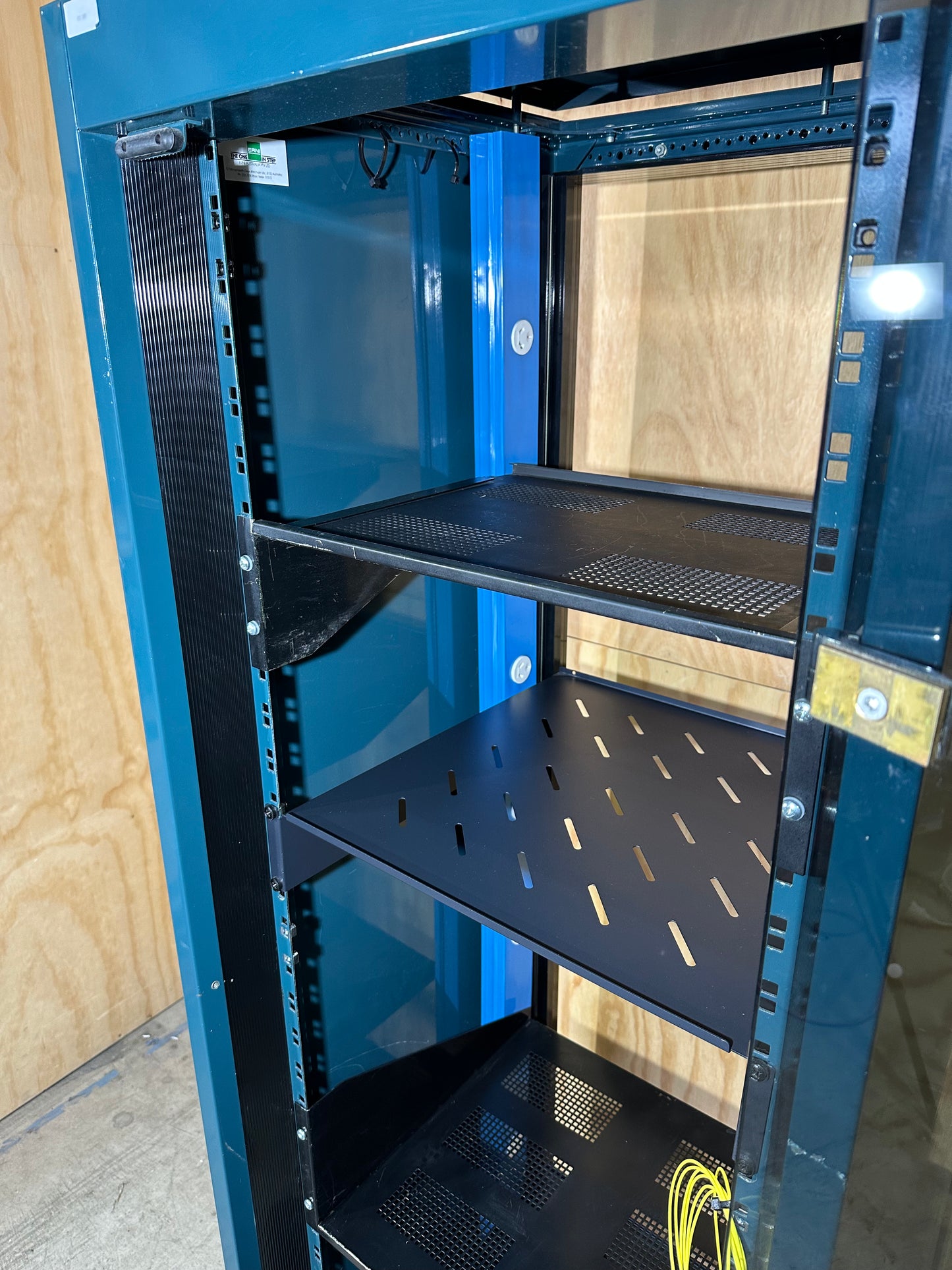 Tall dark green server cabinet with glass doors