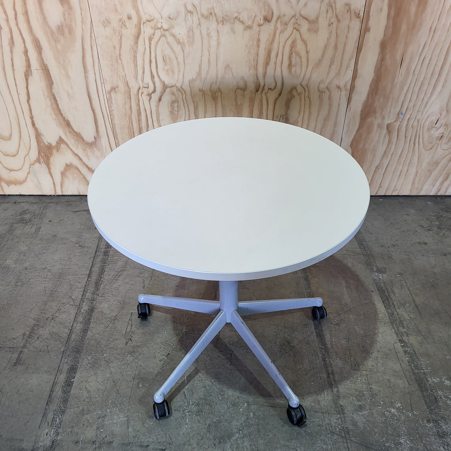Round white table on 5 star castors
