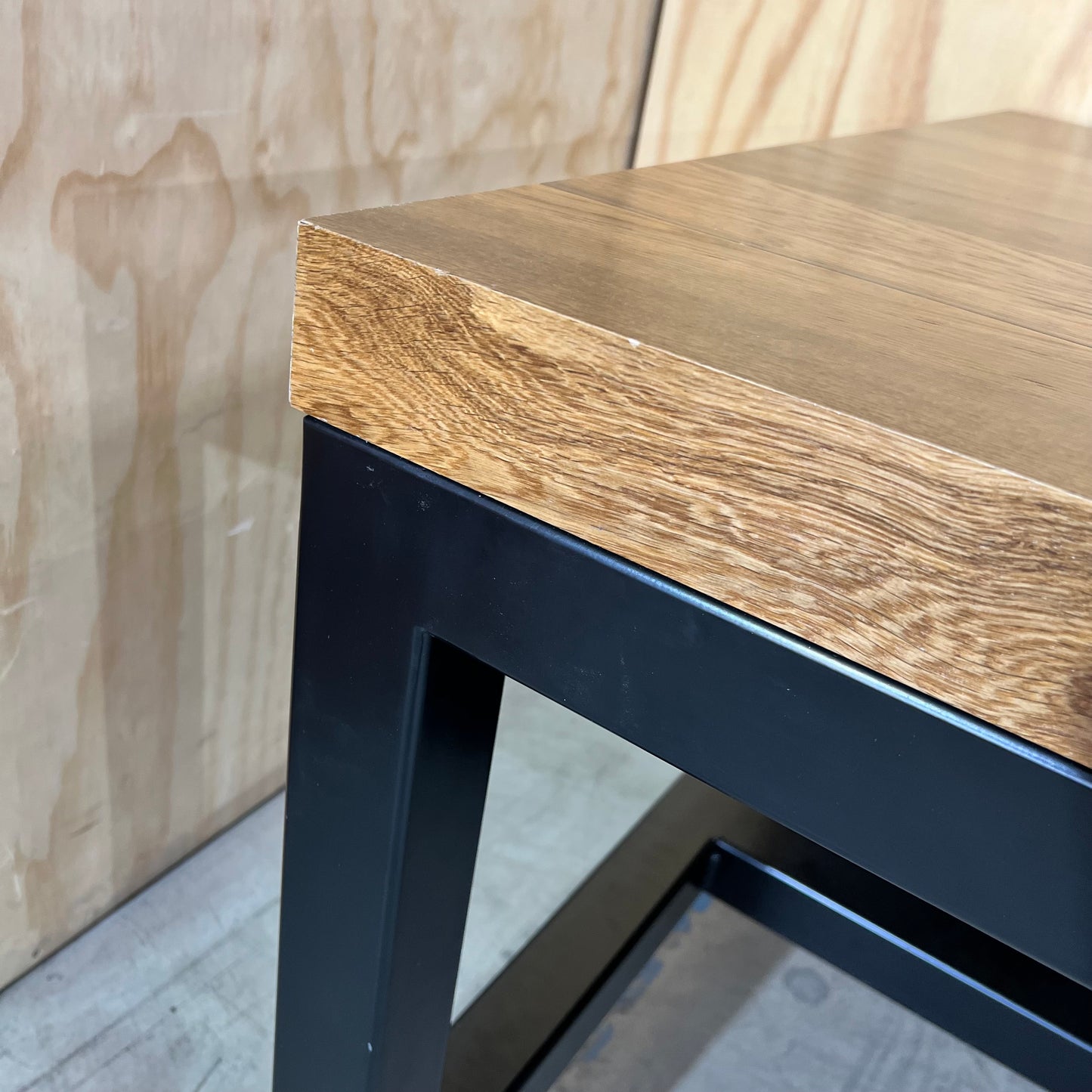 Timber table on black metal frame with castors
