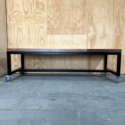 Timber table on black metal frame with castors