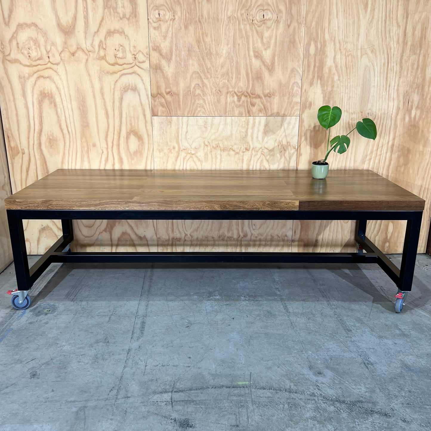 Timber table on black metal frame with castors