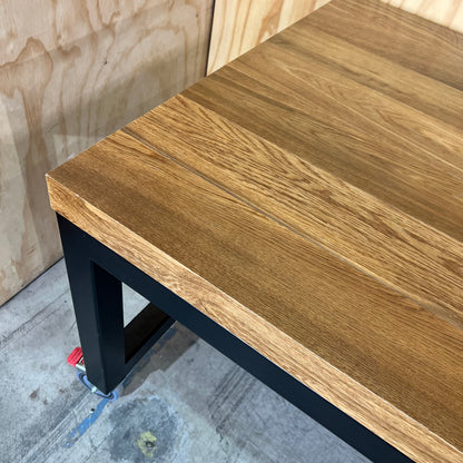 Timber table on black metal frame with castors