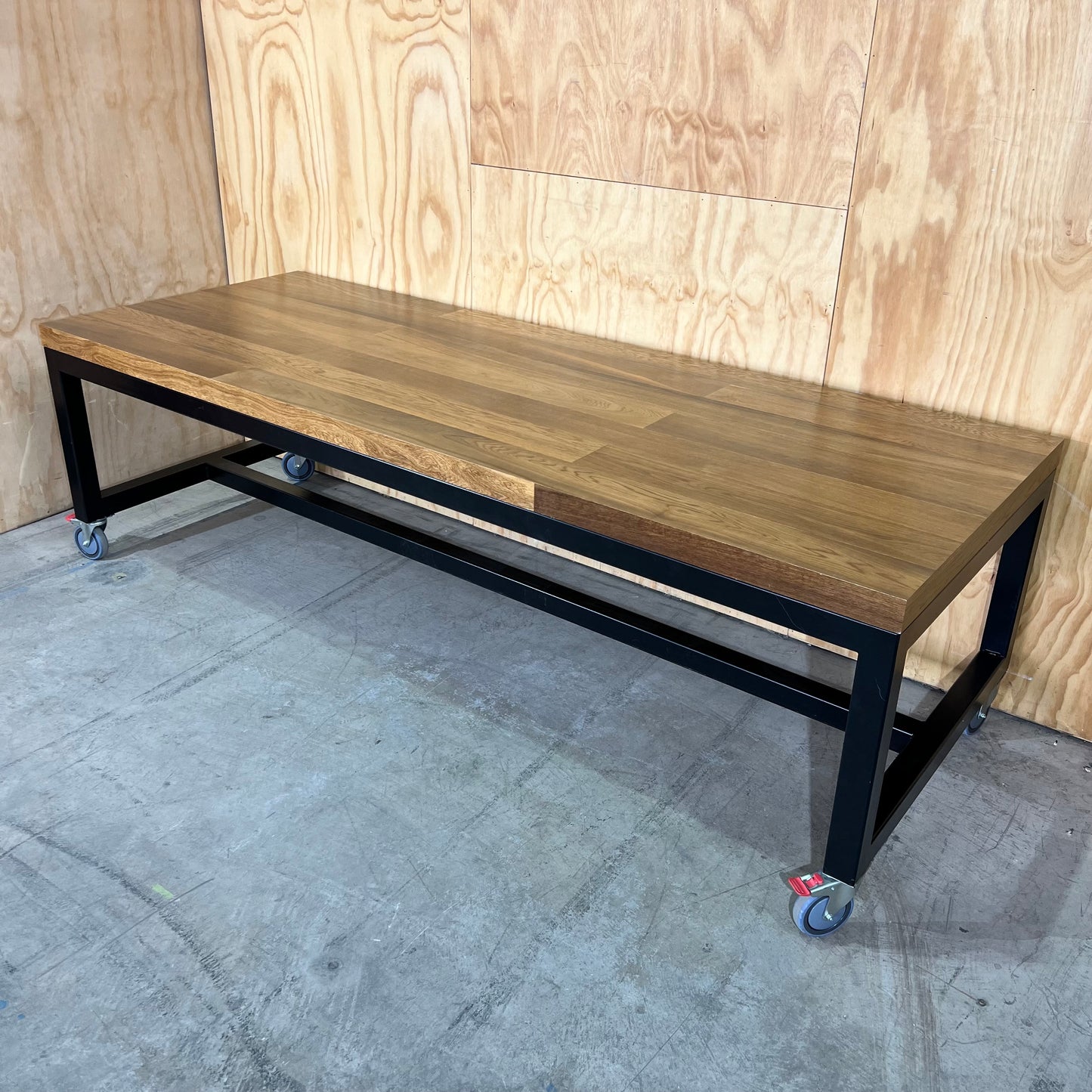Timber table on black metal frame with castors