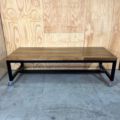 Timber table on black metal frame with castors