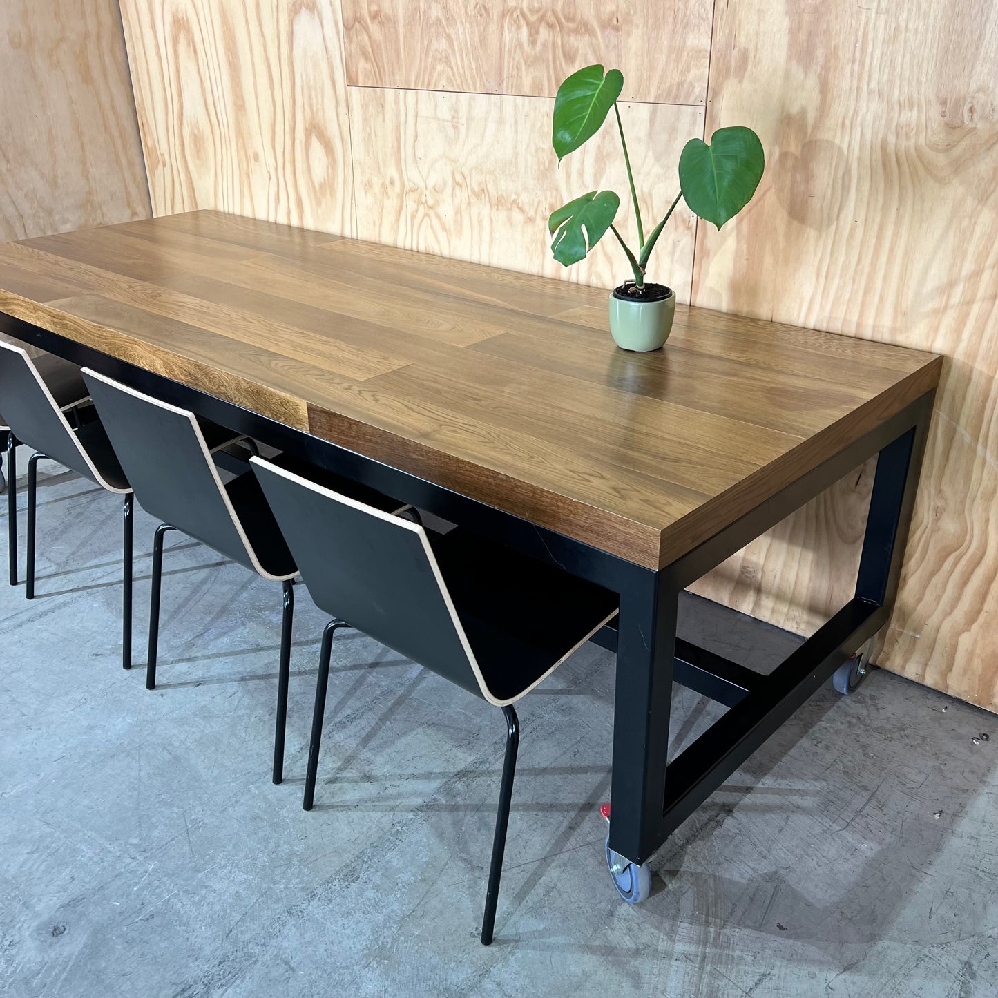 Timber table on black metal frame with castors