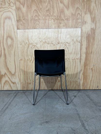 Set of 11 black stackable cushioned chairs with trolley