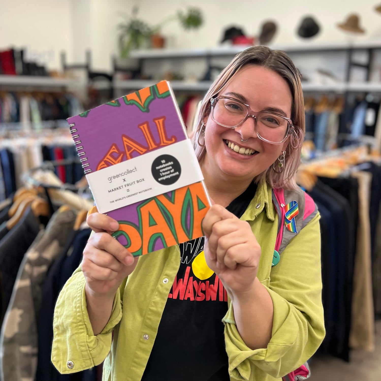 Laura holding upcycled fruit basket notebook made in Green Collect's braybrook warehouse

