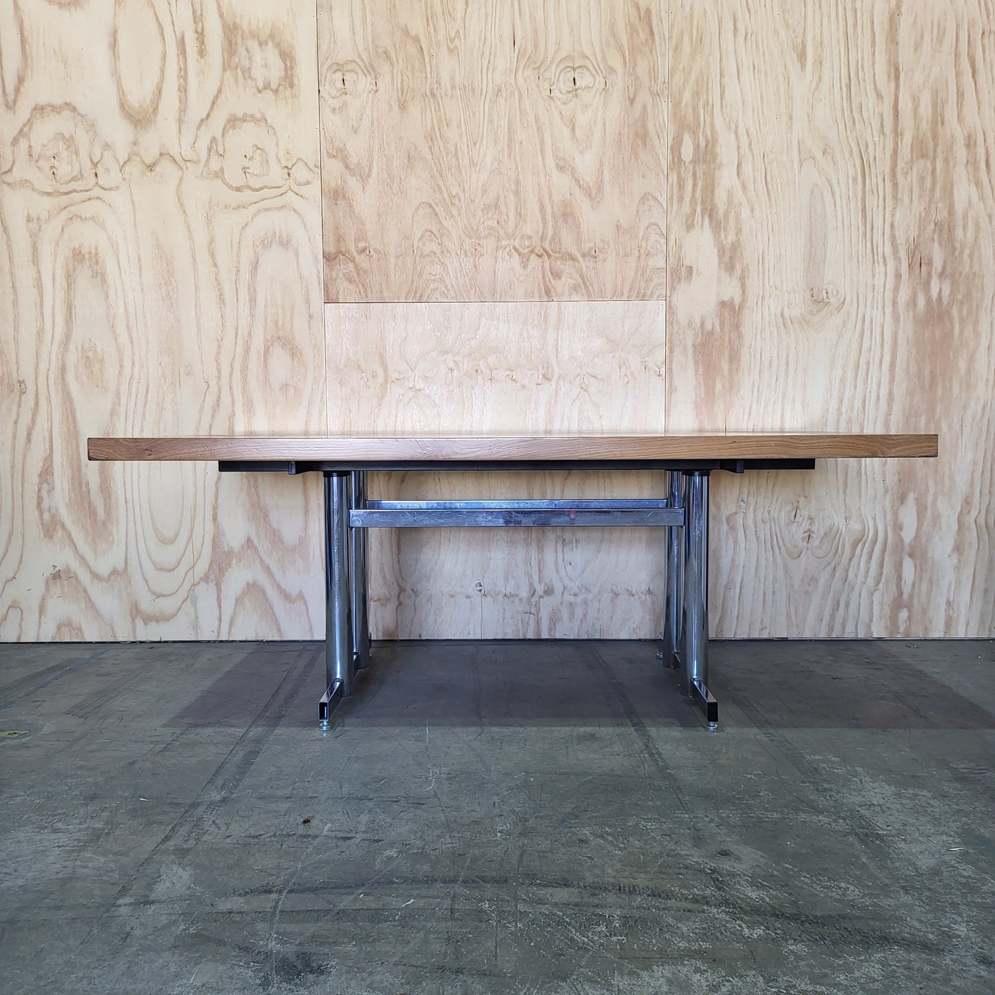 Timber veneer meeting table on chrome steel legs